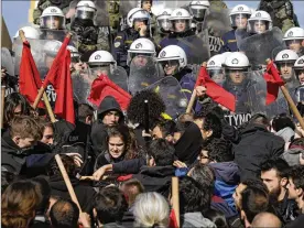  ?? THANASSIS STAVRAKIS / ASSOCIATED PRESS ?? Police clash with protesters on the steps of parliament in Athens at a rally Friday against a new austerity bill that will limit the right to strike and speed up property foreclosur­es. More than 8,000 protesters participat­ed in the rally.