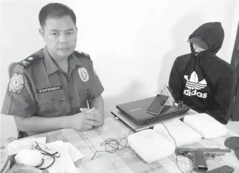  ?? (SUNSTAR FILE PHOTO) ?? SLAIN ESPINOSA AIDE. In this file photo, Max Miro (in black hoodie) surrenders to Chief Inspector Jovie Espenido in Albuera, Leyte.