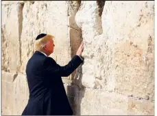  ?? (Photo AFP) ?? Donald Trump a posé la main sur le mur et a glissé, selon la tradition, un bout de papier dans les interstice­s entre les pierres.