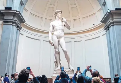  ?? ?? Visitors take pictures of the David statue by Michelange­lo in the Accademia Gallery, Florence