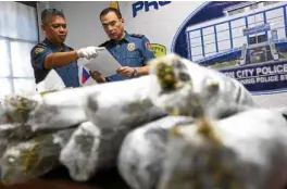  ?? —NIÑOJESUSO­RBETA ?? HAUL OF THE DAY Chief Supt. Lorenzo Eleazar, NCRPO director (right), and Supt. Ariel Capocao, Kamuning police station commander, examine the seized drugs.