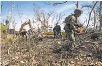  ?? U.S. NAVY VIA GETTY IMAGES ?? U.S. Marines have joined civilians to clear roads still blocked by debris more than a week after Maria.