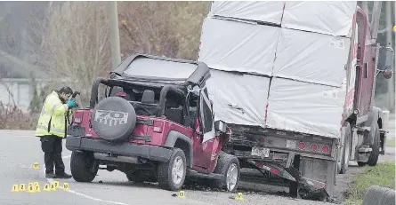  ?? — NICK PROCAYLO/PNG ?? Delta police probe the scene of a crash between a truck and a Jeep on Ladner Trunk Road and 104th Street in Delta on Sunday. The accident claimed the life of a Surrey firefighte­r.