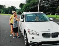  ?? BOB KEELER — DIGITAL FIRST MEDIA ?? Tyler Gunning, center, with Amanda Walter, left, delivers a lemonade to a driver at the Alex’s Lemonade Stand at Oak Ridge Elementary School.