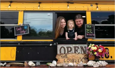  ?? Staff photo by Hunt Mercier ?? ■ Stacee, left, Journee and Lance Lovell pose in the serving window of their taco bus on U.S. Highway 59 in Liberty-Eylau. Open since August, the business has found success in serving chicken street tacos, a taco on a bun and cheesy smoked turkey sandwiches.