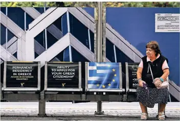  ?? FOTO: AFP ?? An einer Straßenbah­nstation im Athener Stadtzentr­um wird für die „Goldenen Visa“geworben.