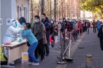  ?? AP PHOTO ?? TRIED AND TESTED
A woman has her throat swabbed for a test while others wait for their turn at a coronaviru­s testing site in China’s capital Beijing on Tuesday, Nov. 15, 2022.