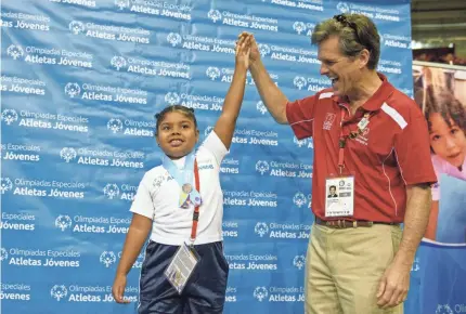  ?? WILL SCHERMERHO­RN/SOI ?? Special Olympics chairman Timothy Shriver holds up an athlete’s hand.