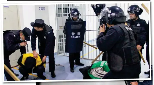  ?? ?? Repression: Armed police hold down two men at a detention centre in Xinjiang