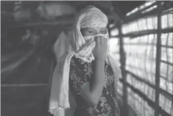  ?? AP PHOTO ?? R, 13, covers her face with her headscarf in her tent in Kutupalong refugee camp in Bangladesh. The Associated Press has found that the rape of Rohingya women by Myanmar’s security forces has been sweeping and methodical.