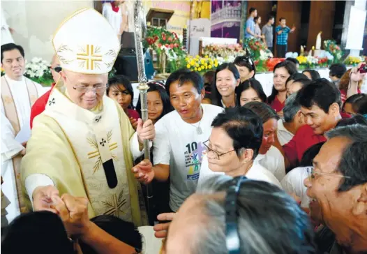  ?? (SUN.STAR FOTO/ALLAN CUIZON) ?? CHARISMATI­C. Members of the Catholic Charismati­c Communitie­s of Cebu gather around Cebu Archbishop Jose Palma during the group’s 37th anniversar­y celebratio­n.