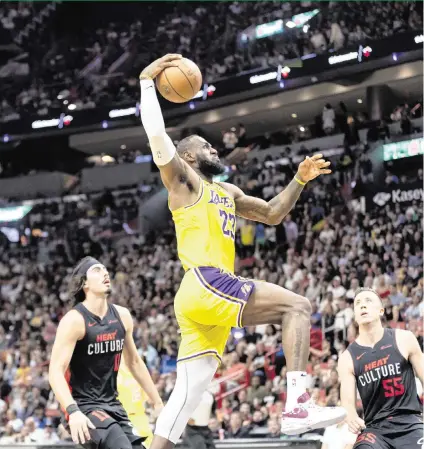  ?? MATIAS J. OCNER mocner@miamiheral­d.com ?? The Heat’s Jaime Jaquez Jr., left, and Duncan Robinson can only watch as the Lakers’ LeBron James flies toward the basket Nov. 6 in a 108-107 Miami victory at Kaseya Center. James scored 30 points.