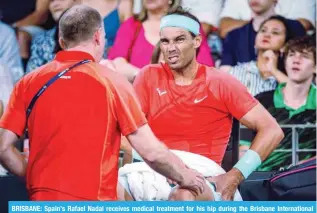  ?? — AFP ?? BRISBANE: Spain’s Rafael Nadal receives medical treatment for his hip during the Brisbane Internatio­nal tennis tournament in Brisbane on January 5, 2024.