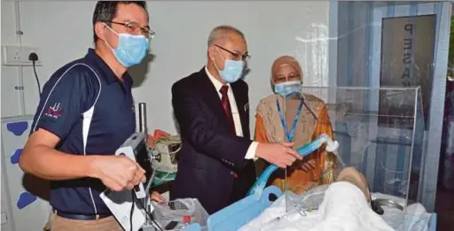  ?? PIC BY VINCENT D’SILVA ?? Dr Ahmad Razid Salleh (centre) demonstrat­ing the use of medical equipment in the Isoresus Chamber. Looking on are Dr Ng Kim Fong (left) and Dr Khadijah Abu Bakar.