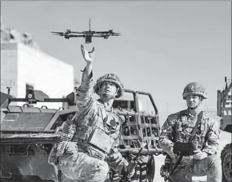  ?? Defense Visual Informatio­n Distributi­on Service ?? BRITISH SOLDIERS launch a drone during exercises at Ft. Irwin in San Bernardino County. Global militaries are preparing for a new kind of warfare led by squadrons of AI-enabled air and sea drones.