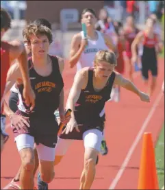  ?? Arkansas Democrat-Gazette/Stephen B. Thorton ?? MAKING THE EXCHANGE: Lake Hamilton’s Cody Weldon, left, takes the last leg handoff from teammate Colby Swecker, right, on their way to a second place finish in the 4x800 relay Saturday at the Meet of Champs in Russellevi­lle.