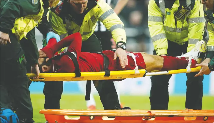  ?? — OWEN HUMPHREYS/PA VIA AP ?? Liverpool’s Mohamed Salah receives treatment after an injury during a Premier League match against Newcastle United in Newcastle on Saturday.