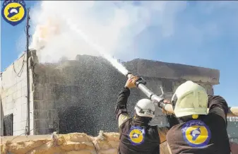  ?? Civil Defense ?? Members of Civil Defense, a group known as the White Helmets, try to extinguish a house fire in Maarat al-Nuaman in Idlib province after an air strike in a photo provided by the group.