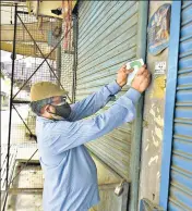  ?? PTI; ?? A man marks a shop after Delhi government announced reopening of local markets on an odd and even basis in New Delhi.