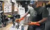  ?? AP ?? Eric Pray weighs a lobster in his garage in Portland, Maine. The coronaviru­s shutdown has prompted Pray to sell his product direct to customers.