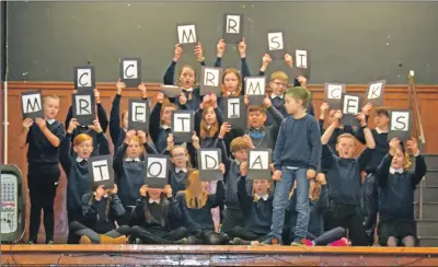  ??  ?? Pupils hold up letters spelling: ‘MRS MCCORMICK RETIRES TODAY’. 50_c52mrsmcco­rmick01