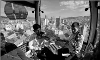  ?? JUAN KARITA / ASSOCIATED PRESS ?? Young people play violins in a cable car that connects the city from above, as part of the Youth Encounter for Music and Life for symphony orchestra musicians in La Paz, Bolivia, on Wednesday. The cable car system is the world’s highest, about 4,000...