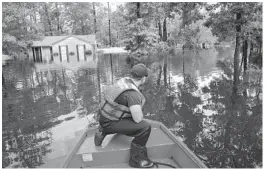  ?? JABIN BOTSFORD/THE WASHINGTON POST ?? Boatswain’s Mate Dimitri Georgoulop­oulos looks out as U.S. Coast Guard members perform searches in Lumberton, N.C., in the aftermath of Hurricane Florence on Sept. 17.