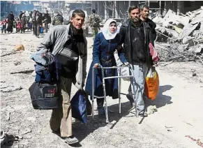  ?? — AFP ?? Hard walk ahead: A Syrian girl using a walker evacuates with other civilians from the town of Jisreen in southern Eastern Ghouta on the way to areas under government control.