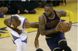  ?? — AP ?? Cleveland Cavaliers forward LeBron James ( right) drives past Golden State Warriors forward Andre Iguodala in their NBA Finals Game 2 on Sunday.