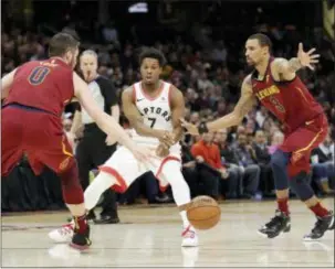  ?? TONY DEJAK — THE ASSOCIATED PRESS ?? Toronto’s Kyle Lowry (7) passes the ball between Cleveland’s Kevin Love (0) and George Hill (3) during the first half Wednesday in Cleveland.