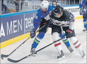  ?? AP PHOTO ?? Canada’s Nate Mackinnon, right, challenges Slovenia’s Sabahudin Kovacevic, left, during the Ice Hockey World Championsh­ips in Paris, France on Sunday.