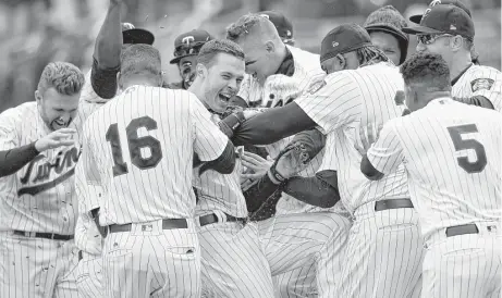  ?? Hannah Foslien / Getty Images ?? Twins outfielder Max Kepler, center, finds himself in the middle of a Minnesota mob after hitting a game-ending homer at Target Field.