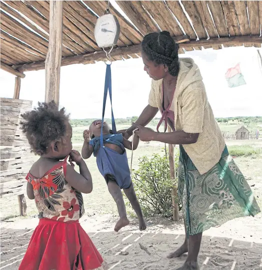  ??  ?? HUNGER DIET: A woman checking the weight of her baby at the health centre of Imongy village, in the Tsihombe district of southern Madagascar.