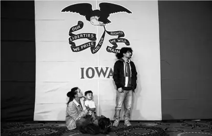  ?? MATT ROURKE/AP ?? Natalie Serrano, left, and Isaac Garcia watch caucus returns come in with their son Leonel, 2, at a caucus night campaign rally.