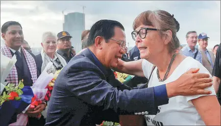  ?? REUTERS ?? Cambodian Prime Minister Hun Sen (left) welcomes a Westerdam passenger as the cruise ship docks in Sihanoukvi­lle on Friday.