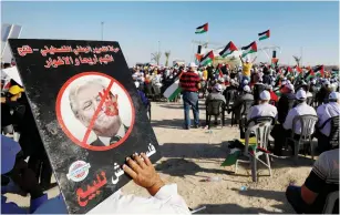  ?? (Mohamad Torokman/Reuters) ?? A DEMONSTRAT­OR holds a placard with US President Donald Trump on it during yesterday’s Jericho rally, organized by the PLO to protest against Israel’s plan to annex parts of the West Bank.