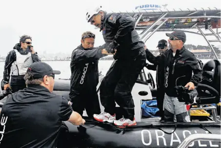  ?? Michael Macor / The Chronicle ?? Mayor Ed Lee is helped aboard the Oracle Team USA catamaran as the team practices for the America’s Cup World Series races.