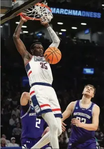  ?? FRANK FRANKLIN II/ASSOCIATED PRESS ?? UConn forward Samson Johnson dunks in front of Northweste­rn forward Luke Hunger (right) during the second half Sunday in New York. UConn won 75-58 and has looked dominant in the first two rounds of the NCAA Tournament.