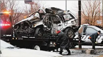  ?? ABEL URIBE/CHICAGO TRIBUNE ?? A tow truck operator lifts the remains of an SUV after a single-car crash near the intersecti­on of Cicero Avenue and Roosevelt Road left several people dead on Dec. 12. The SUV crashed into a building.
