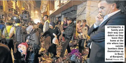  ?? Picture: EPA ?? AFTERMATH: A
family pick their way over debris as they
leave their home at the site where two
suicide bombers blew themselves up
in Bourj al-Barajneh, Beirut