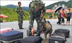  ?? LIN YIGUANG / XINHUA ?? Narcotics control officers inspect passengers’ luggage at a border area in Yunnan province.