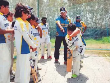  ?? Courtesy: DCCA. ?? Romesh Kaluwithar­ana offers his expertise to youngsters during the Desert Cubs Cricket Academy Cricket Fiesta in Dubai.