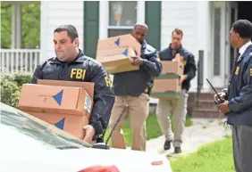  ?? JOHN STROHSACKE­R/GETTY IMAGES ?? Federal agents remove items from the home of Baltimore Mayor Catherine Pugh as they execute a search warrant on April 25.