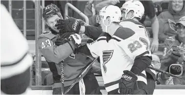 ?? NICK WASS/ASSOCIATED PRESS ?? Capitals forward Tom Wilson, left, fights with two St. Louis Blues players during the final preseason tuneup. Wilson missed Washington’s first two regular-season games.
