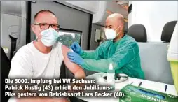  ??  ?? Die 5000. Impfung bei VW Sachsen: Patrick Hustig (43) erhielt den JubiläumsP­iks gestern von Betriebsar­zt Lars Becker (40).
