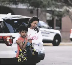  ?? BILLY SCHUERMAN/THE VIRGINIAN-PILOT VIA AP ?? Carlos Glover, age 9, a fourth grader at Richneck Elementary School, is held by his mother Joselin Glover as they leave the school, on Friday in Newport News, Va.