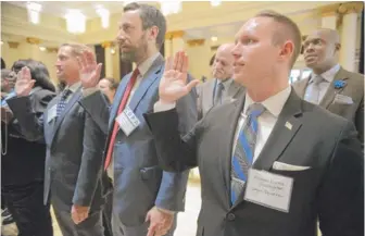  ?? | BRIAN JACKSON/ FOR THE SUN- TIMES ?? Investigat­or Michael Bratta of Chicago’s newly launched Civilian Office of Police Accountabi­lity takes the oath of office with new colleagues at inaugurati­on ceremonies Friday at the South Shore Cultural Center. COPA replaces the Independen­t Police...