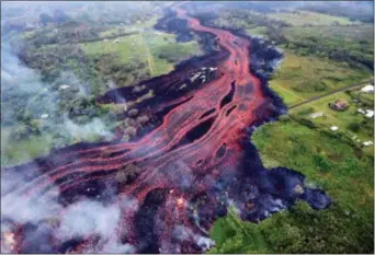  ?? U.S. GEOLOGICAL SURVEY VIA AP ?? In this Saturday photo released by the U.S. Geological Survey, lava flows from fissures near Pahoa, Hawaii. Kilauea volcano began erupting more than two weeks ago and has burned dozens of homes, forced people to flee and shot up plumes of steam from...