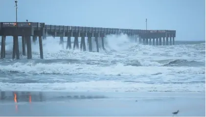  ?? Picture: AFP ?? ‘DANGEROUS’. Waves crash along a pier as the outerbands of hurricane Michael arrive yesterday in Panama City Beach, Florida. The hurricane is forecast to hit the Florida Panhandle as a category 4 storm.