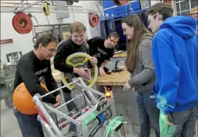  ??  ?? Chartiers Valley High School teacher Jeff Macek, left, joins robotics team members Jack Radzanowsk­i, team mentor Dane Bennington, Clare Malone and Austin DeLong to work on a project.